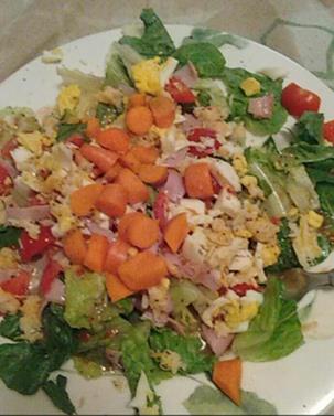 Plate of salad with egg, ham, and vegetables