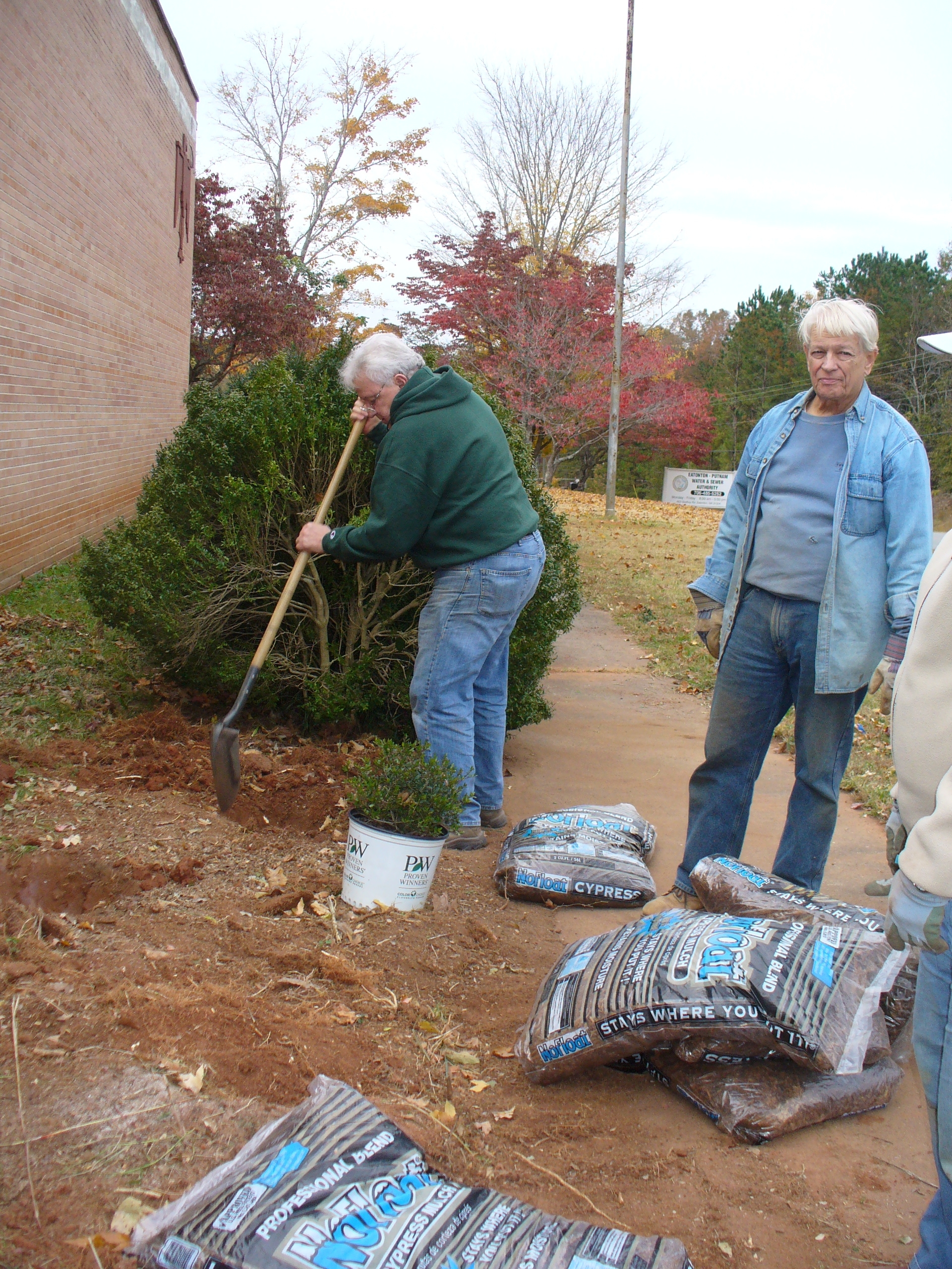 Master Gardener volunteers dig holes for planting new bushes