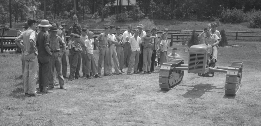 Black-and-white photo of a demonstration of farm equipment