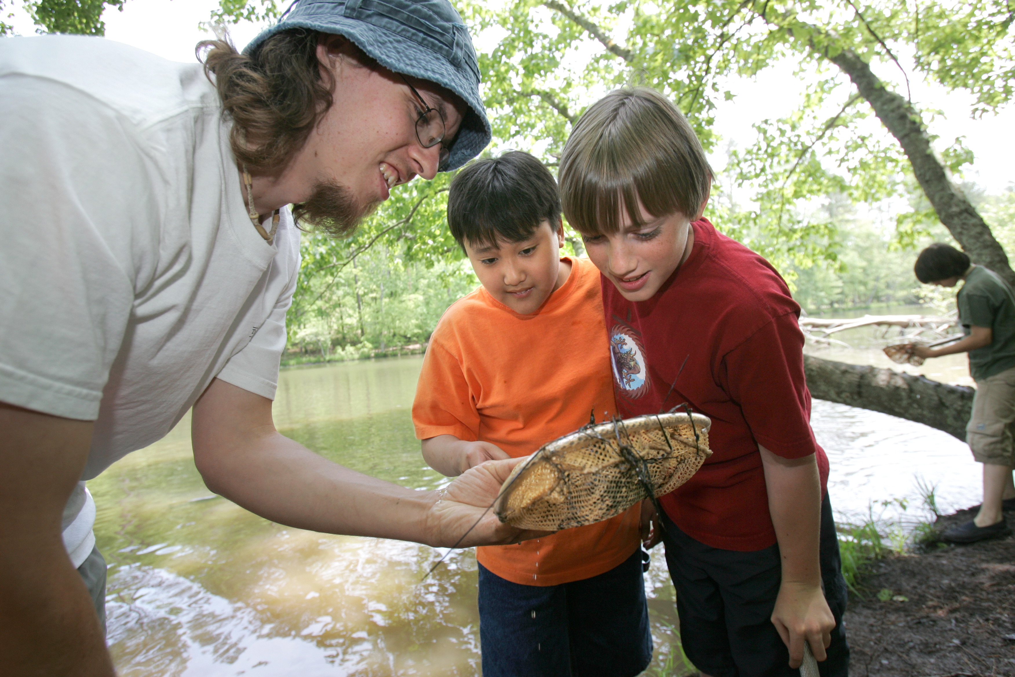 4-H agent shows a stream sample to a pair of children