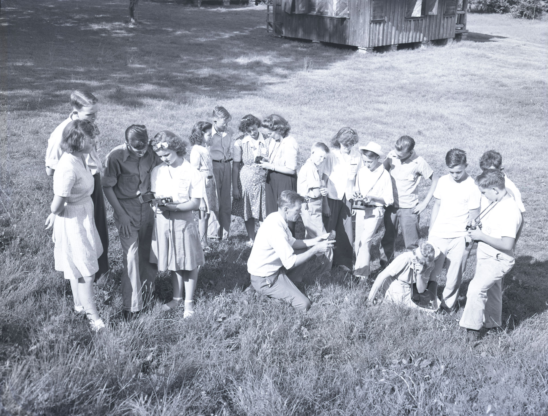 4-H'ers sit and stand in a field